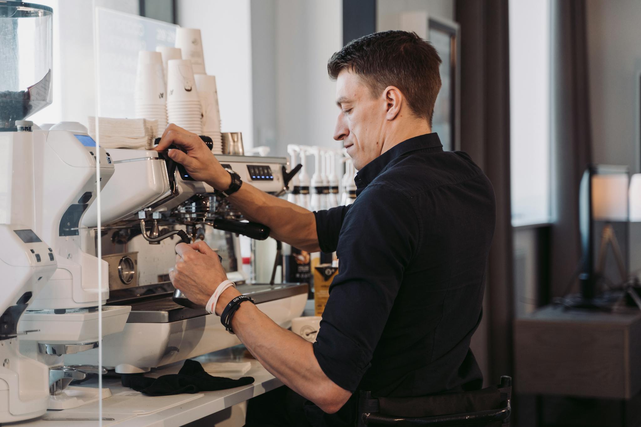 A barista skillfully making espresso in a contemporary cafe setting.